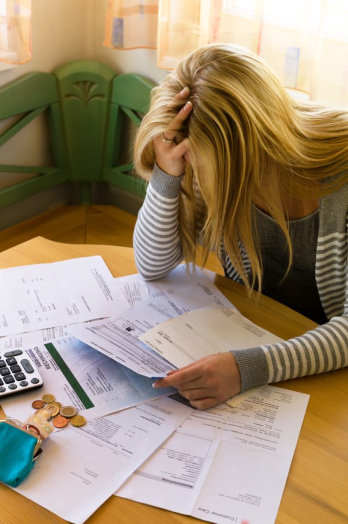 Woman looking at bills and frustrated